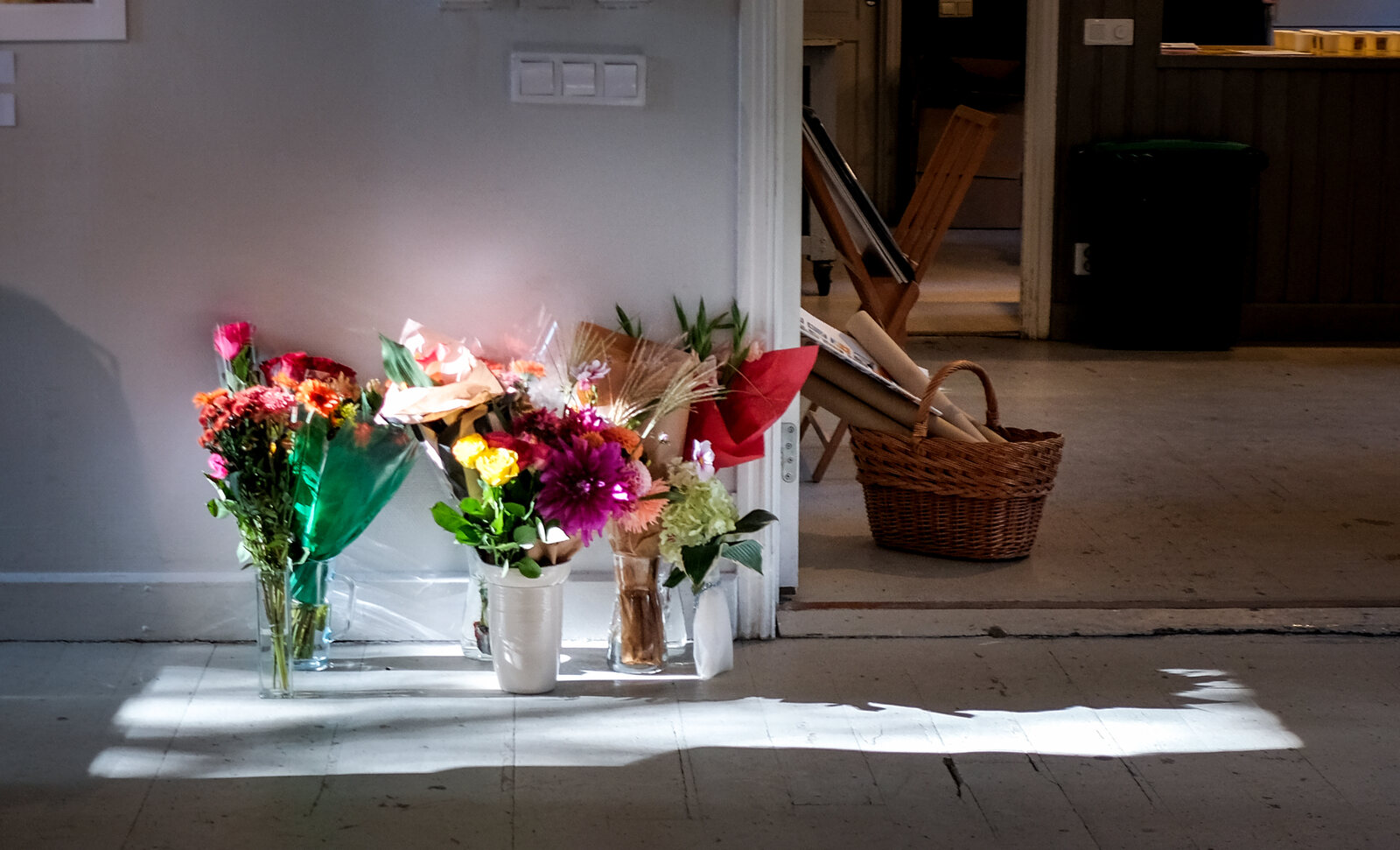 Blombuketter på golvet i ett solstrålsljus.